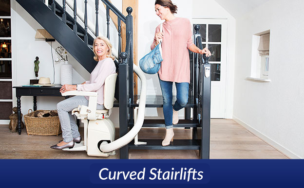 Stairlift with woman seated on curved staircase